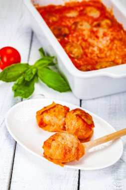 Beyaz tabakta domates ve ekşi krema soslu köfte. Yakın çekim