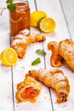 Limonlu kruvasanları Beyaz ahşap arka plan üzerinde reçel. Yakın çekim