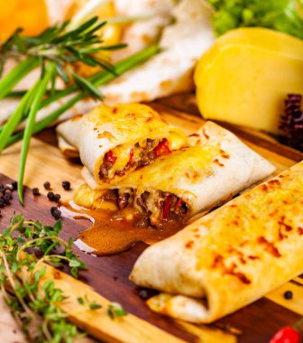 Et ve sebze ahşap kesme tahtası üzerinde burrito dolu