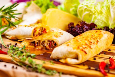 Et ve sebze ahşap kesme tahtası üzerinde burrito dolu