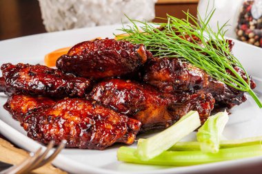 Beyaz tabakta çıtır sebzeli tavuk kanadı. Kapat.