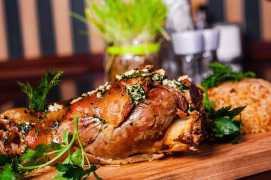 Alman usulü kavrulmuş domuz paçası (eklem, bacak) ve tahta kesme tahtasında pirinç.