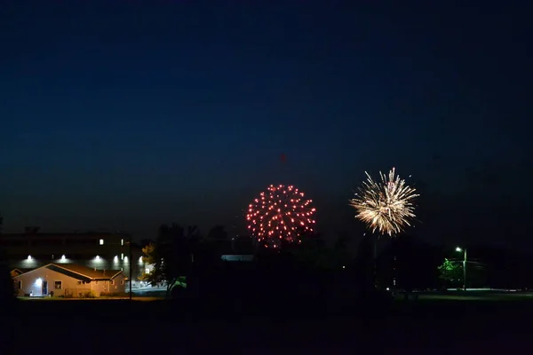 viewing fireworks from a field at night in a small town