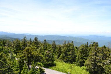 Dağları ve mavi gökyüzü olan güzel bir manzara.