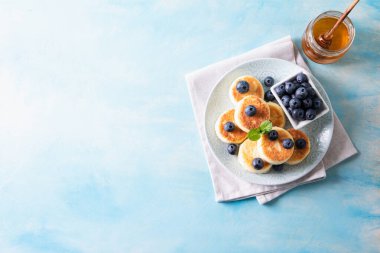 Süzme peynirli krep. Süzme peynirden peynirli kekler, lezzetli kahvaltı, geleneksel Rus tatlı krepleri. Yabanmersini, nane ve bal ile.