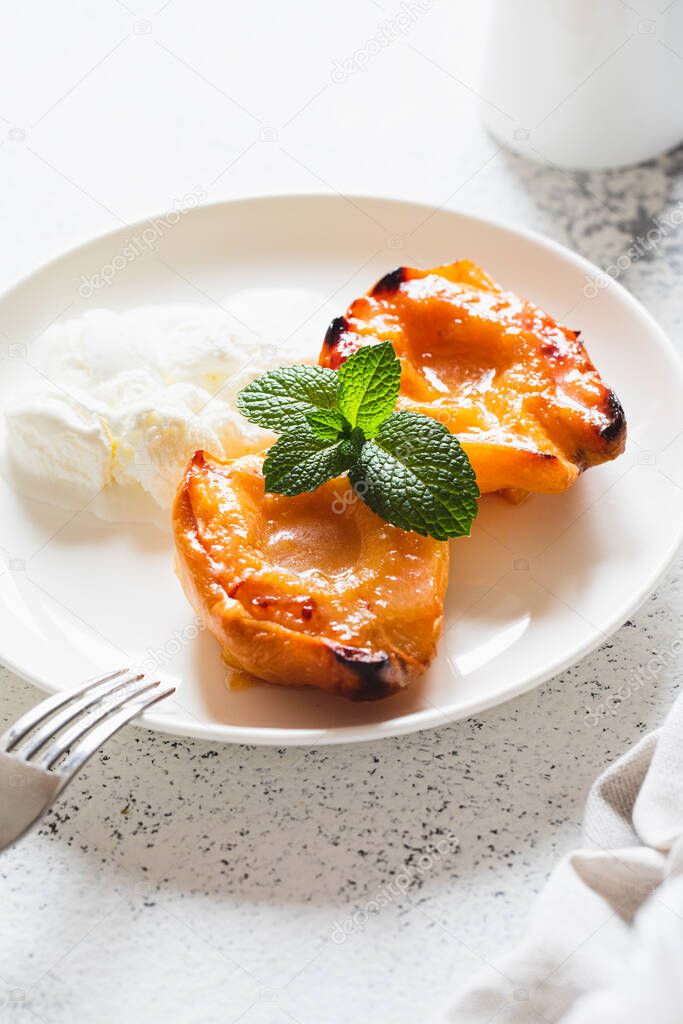 Apple quince baked with honey on a white plate with ice cream. Healthy vegetarian dessert.