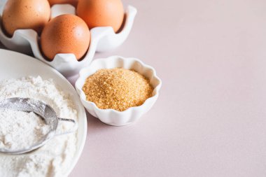 Pişirme ya da pişirme arka plan çerçevesi. Malzemeler, kek pişirmek için mutfak malzemeleri. Mutfak aletleri, un, yumurta, esmer şeker, tereyağı. Metin uzayı, üst görünüm. Kurabiye Turtası ya da Pasta Tarifi