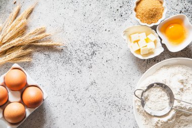 Pişirme ya da pişirme arka plan çerçevesi. Malzemeler, kek pişirmek için mutfak malzemeleri. Mutfak aletleri, un, yumurta, esmer şeker, tereyağı. Metin uzayı, üst görünüm. Kurabiye Turtası ya da Pasta Tarifi