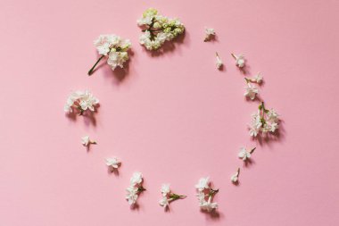 Pembe kâğıt üzerindeki leylak deseninden yaratıcı bir tebrik. Bahar çiçeği konsepti. Düz konum, üst görünüm, kopyalama alanı.