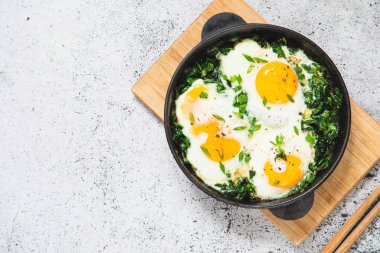 Dökme demir tavada yeşil Shakshuka. Ispanaklı yumurta ve kızarmış tost. sağlıklı besleyici kahvaltı,