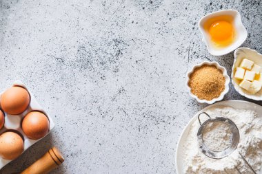 Pişirme ya da pişirme arka plan çerçevesi. Malzemeler, kek pişirmek için mutfak malzemeleri. Mutfak aletleri, un, yumurta, esmer şeker, tereyağı. Metin uzayı, üst görünüm. Kurabiye Turtası ya da Pasta Tarifi