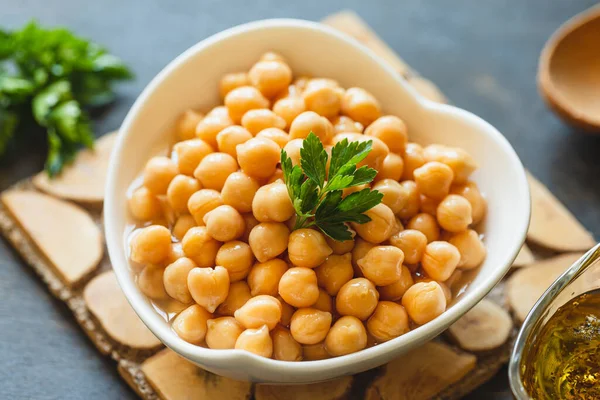 Cooked chickpeas in white bowl. Ingredient for Tasty vegetarian food. Boiled chickpeas, selective focus
