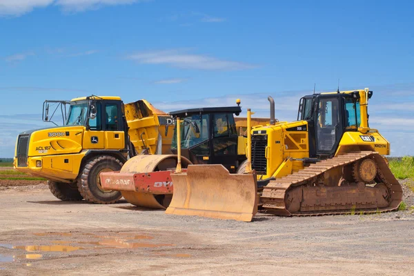 Truro, İngiltere - 10 Haziran 2018: Caterpillar buldozer, Dynapac silindir ve John Deere damperli kamyon güneşli bir günde dışarıda.