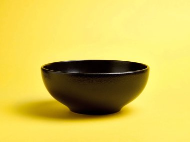 Sarı zemin üzerinde boş siyah seramik kase