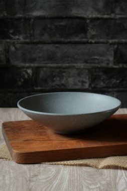 Tahta tepside boş bir kase ve bir kamış peçetesi