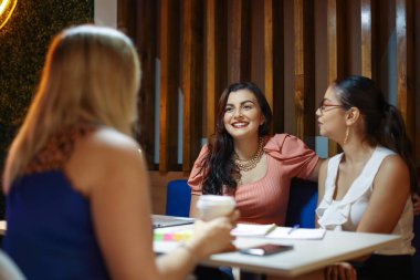 Students sitting talking at cafe as friends. High quality photo
