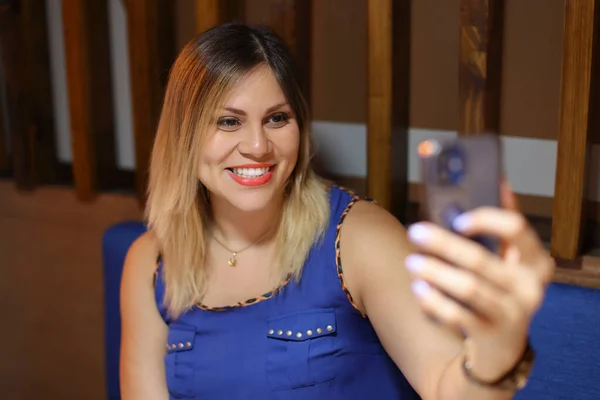 Girişimci kadın kafeteryada telefonuyla selfie çekiyor. Yüksek kalite fotoğraf