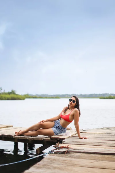 Bocas del Toro Panama 'daki iskelede oturan genç Latin kadın. Yüksek kalite fotoğraf