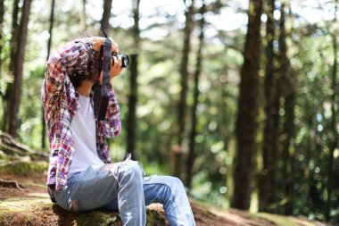Kosta Rika 'da elinde kamerayla ormanın içinde fotoğraf çeken yüzsüz fotoğrafçı. Yüksek kalite fotoğraf