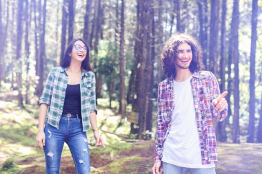 Kosta Rika 'daki ormanda gülümseyen ve işaret eden genç Latin çift. Yüksek kalite fotoğraf