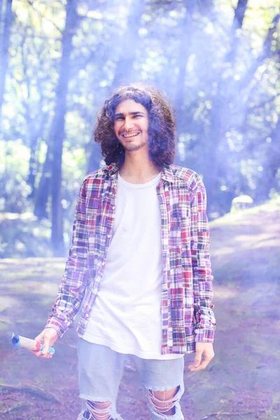 Kosta Rika 'da elinde mavi bir sis bombası tutan gülümseyen Latin Amerikalı genç bir adam. Yüksek kalite fotoğraf