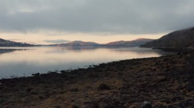 The beautiful sunset sky over a lake in Trossachs National Park in Scotland - wide rolling