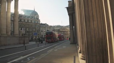 Bank of England and Red London Buses in empty roads and quiet streets with no traffic during Coronavirus pandemic Covid-19 lockdown, taken at rush hour in the City of London, England, Europe