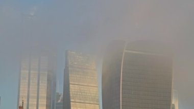 Skyscrapers in City of London in mist in the business area showing Walkie Talkie building and other offices on a misty morning of the Covid-19 Coronavirus lockdown in England, Europe