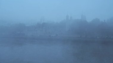 Coronavirus Covid-19 lockdown day one in thick foggy weather conditions at Tower of London on a misty cool blue atmospheric morning with fog and mist on the River Thames in London, England, UK