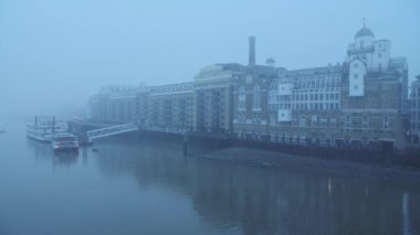 Butlers Wharf Pier and River Thames in thick fog and mist, on a cool blue morning in foggy and misty moody weather in London city centre during Covid-19 Coronavirus lockdown, England, UK