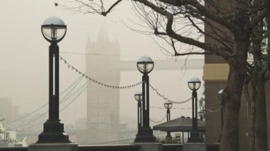Iconic Tower Bridge in London with orange misty sunrise in mist and fog in atmospheric day one of Coronavirus Covid-19 lockdown in England, UK