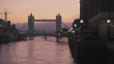 Tower Bridge in London with beautiful colourful sunrise, dramatic clouds and orange sky, showing iconic famous skyline on day one of Coronavirus Covid-19 lockdown in England, UK