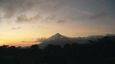 Costa Rica Timelapse, Time Lapse of Arenal Volcano Landscape with Beautiful Rainforest Scenery and Dramatic Orange Sunset Sky and Clouds Moving Past the Summit, Central America