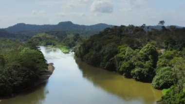 Aerial Drone View of Rainforest River and Mountains Scenery in Costa Rica at Boca Tapada, San Carlos River (Rio San Carlos) that Connects to Nicaragua in Central America, High Shot Above Trees