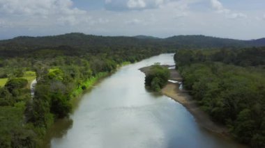 Aerial Drone View of Rainforest River and Mountains Scenery in Costa Rica at Boca Tapada, San Carlos River (Rio San Carlos) that Connects to Nicaragua in Central America, High Shot Above Trees