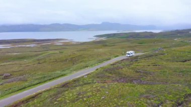 Aerial Drone View of Car Driving on Roads of Scottish Highlands, Scotland, on Road Trip Holiday with Beautiful Mountain Landscape Scenery, NC500 (North Coast 500 Route) Adventure