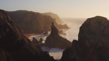 Aerial Drone View of Cliffs and Dramatic Portugal Coast Scenery at Lisbon, Atlantic Ocean and Coastal Waves Landscape of Rock Formations, Rocks and Rocky Coastline, Europe With Orange Sunset Light