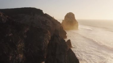 Aerial Drone View of Cliffs and Dramatic Portugal Coast Scenery at Lisbon, Atlantic Ocean and Coastal Waves Landscape of Rock Formations, Rocks and Rocky Coastline, Europe With Orange Sunset Light