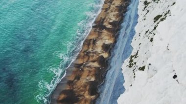 Coastline Aerial Drone of Ocean Waves Breaking on Sandy Beach by White Chalk Cliffs on Coast showing Patterns and Beauty in Nature