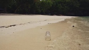 Rubbish on Beach, Single Use Plastic Bottle in Waves on Sandy Shore of White Sand, Garbage Trash and Waste Causing a Human Impact on Marine Conservation and Water Pollution in Asia
