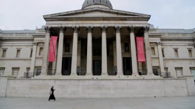 Quiet and empty Central London in Covid-19 Coronavirus lockdown with one person walking at The National Gallery at Trafalgar Square, a popular tourist attraction in England, UK
