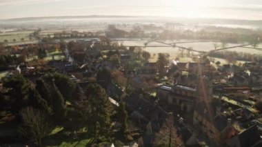 Aerial drone video of a Cotswolds Village, English countryside fields and scenery with houses, property and real estate in the UK housing market, Bourton on the Hill, Gloucestershire, England