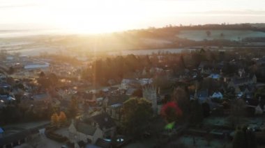 Aerial drone video of Typical English village and beautiful British countryside scenery in The Cotswolds showing a rural church at sunrise in beautiful morning light at Longborough, Gloucestershire, England, UK