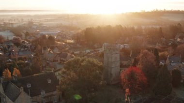 Aerial drone video of Typical English village and beautiful British countryside scenery in The Cotswolds showing a rural church at sunrise in morning sun at Longborough, Gloucestershire, England, UK