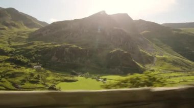 Scenic Drive Through The Lush Green Mountain Terrain During Sunset In Snowdonia National Park In Wales - Wide Shot