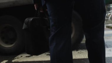 A businessman walking up stairs to an office building with a briefcase