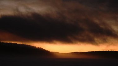 The stunning view of the sunset over the dark land of Lapland, Finland during the evening