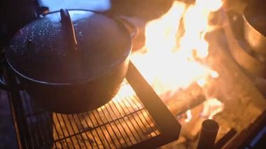 Cooking in a metal pot over an outdoor fireplace, in Lapland, Finland