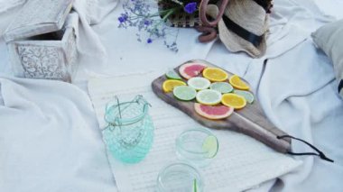 Luxury picnic set up for a romantic date with citrus fruits and accessories at the beach - Close Up Shot