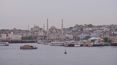 Turkish mosques landscape view across the Golden Horn, with cruises passing by, Istanbul, Turkey, at dusk